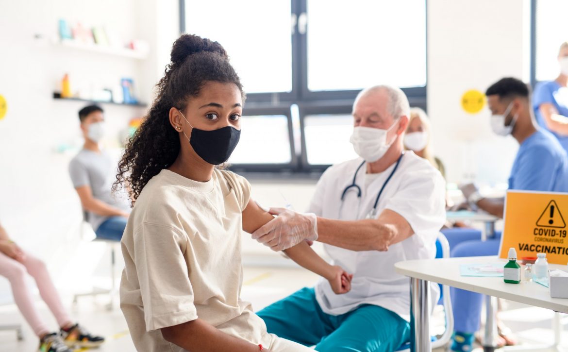 Child with face mask getting vaccinated, coronavirus, covid-19 and vaccination concept.